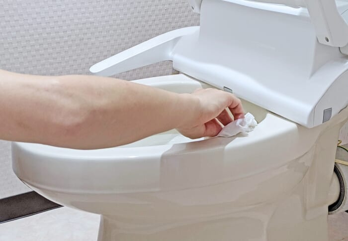 タンクレストイレを拭き掃除している様子