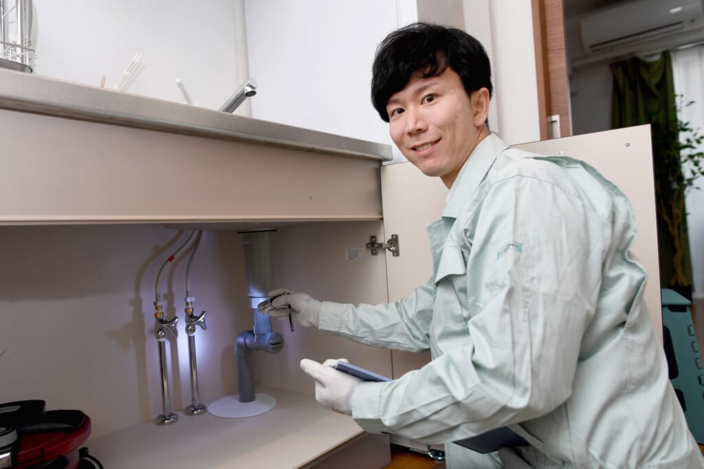 洗面所で交換する蛇口をチェックする業者