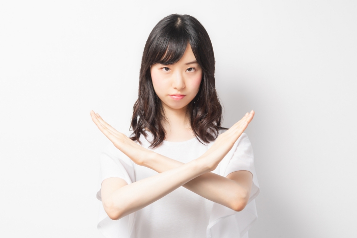 NGのジェスチャーをする女性