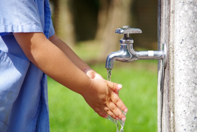 水道で手を洗う人